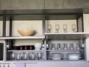 a cabinet filled with glasses and plates and bowls at Sunset Studio Apartment in Poprad