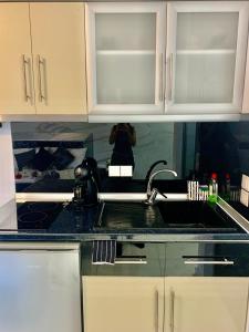 a kitchen counter with a sink and a person taking a picture at petros house in Sarti