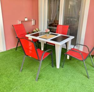 a table and four chairs on a green floor at petros house in Sarti
