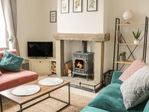 a living room with a fireplace and a stove at Crag View Cottage in Skipton