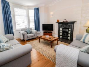 a living room with a fireplace and a tv at 3 St Davids Place in Llandudno