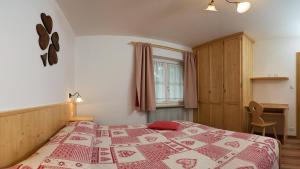 ヴィーゴ・ディ・ファッサにあるMajon Vajolet - Apartments Luisaのベッドルーム1室(ベッド1台、赤と白の毛布付)