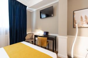 a hotel room with a bed and a desk with a laptop at Pure Hotel by Athens Prime Hotels in Athens