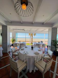 uma sala de jantar com mesas e cadeiras e o oceano em Bahía Serena em Roquetas de Mar