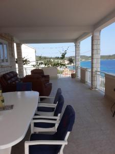 a balcony with a table and chairs and the water at MERICA Kneže in Korčula