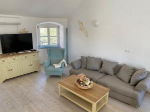 a living room with a couch and a table at Spacious 2 storey apartment old town Mali Lošinj in Mali Lošinj