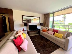 ein Wohnzimmer mit einem Sofa und bunten Kissen in der Unterkunft Albufeira Salgados Premium 1 With Pool by Homing in Guia