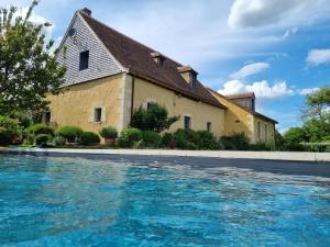 uma casa com piscina em frente a um edifício em La Grange des Bruyères em Igé
