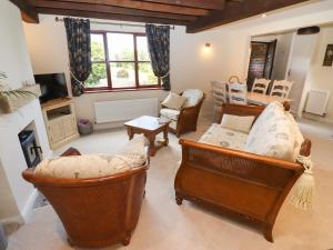 a living room with chairs and a couch and a table at 3 Mount Pleasant in Pershore