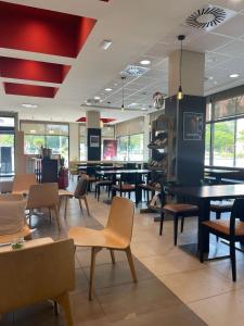 a restaurant with tables and chairs in it at Ibis Ripollet in Ripollet