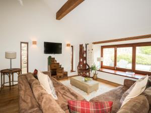 a living room with a couch and a tv at Clynnog House in Dwyran