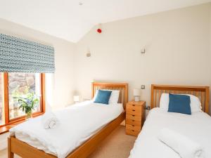 um quarto com 2 camas e uma janela em Clynnog House em Dwyran