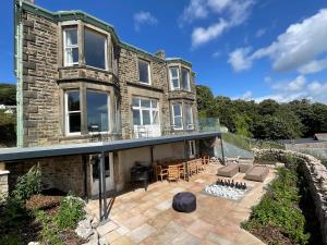 a large stone house with a patio in front of it at Victoria Mount in Grange Over Sands