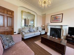 a living room with a couch and a fireplace at Victoria Mount in Grange Over Sands
