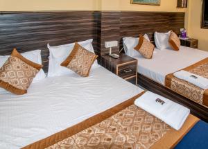 2 camas individuales en una habitación de hotel con faldas en Vrindavan Comfort Inn, en Ameerpet
