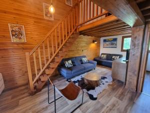 ein Wohnzimmer mit einem Sofa und einer Treppe in der Unterkunft Chalet 8 couchages à 100m du bas des pistes et commerces in Les Angles