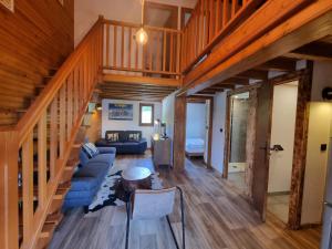 ein Wohnzimmer mit Holztreppe und blauem Sofa in der Unterkunft Chalet 8 couchages à 100m du bas des pistes et commerces in Les Angles