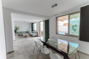 a dining room with a glass table and chairs at Vv Sunny Holiday Villa Maspalomas in Maspalomas