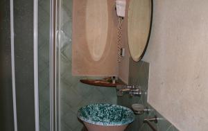 bagno con servizi igienici, lavandino e specchio di Il Canto di Kokopelli Country Houses a Brattirò