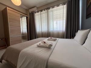 een slaapkamer met een groot wit bed en handdoeken bij City House 2 in Kalamata