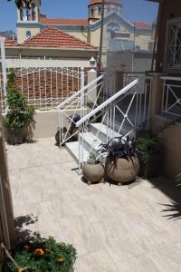 a balcony with potted plants and a white railing at Asteri Apartments Mytikas 2-Bedroom Seaview Courtyard in Mitika