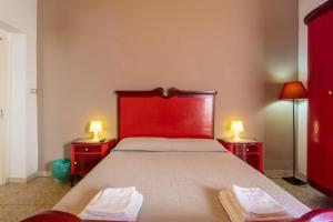 una camera da letto con un letto rosso con due asciugamani di Kalimera Home a Scoglitti