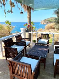 un grupo de bancos de madera sentados en un patio con vistas al océano en ZBB Stylish Villa & Bungalows, en Alanya