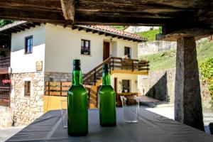 dos botellas de vino sentadas en una mesa con copas en Apartamentos los Balcones de nieda 1 en Cangas de Onís