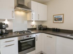 a kitchen with white cabinets and a stove top oven at The Green in Whitby