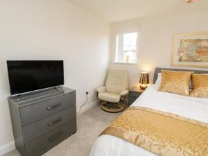 a bedroom with a bed and a flat screen tv at The Green in Whitby