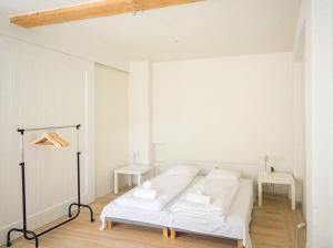 a white bedroom with a bed and two tables at Copenhagen City Flat -cosy backyard & vibrant area in Copenhagen
