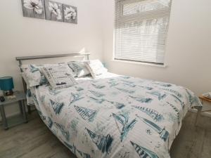 a bedroom with a bed with a blue and white comforter at Ballasalla in Liskeard