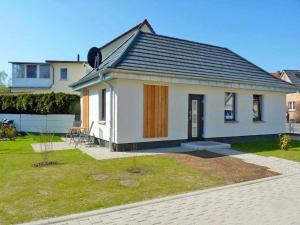 una pequeña casa blanca con una valla en un patio en Ferienhaus "Brigitte" Objekt ID 12053-4 en Waren