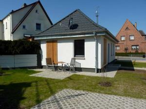 een klein wit huis met een tafel en stoelen bij Ferienhaus "Brigitte" Objekt ID 12053-4 in Waren