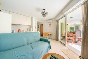 a living room with a blue couch and a kitchen at Novaä in Antibes