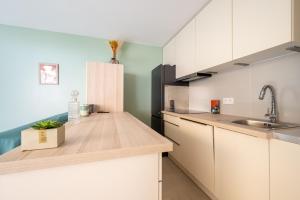a kitchen with white cabinets and a wooden counter top at Novaä in Antibes