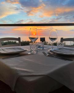 a table with two wine glasses on top of it at Capo Nettuno Hotel in Capo dʼOrlando