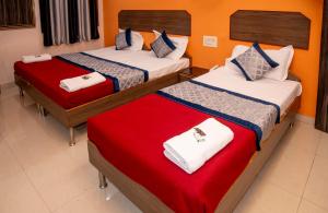 1 dormitorio con 2 camas con sábanas rojas y blancas en Vrindavan Comfort Inn, en Ameerpet