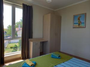 a bedroom with a bed and a large window at вила ФЛОРА in Chernomorets