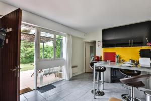 a kitchen with black cabinets and a kitchen island with bar stools at La Presque Basque in Tarnos