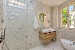 bagno con lavandino, servizi igienici e specchio di Casa Maslina a Vrsar