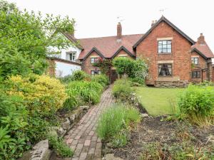 ein altes Backsteinhaus mit einem Backsteinpfad davor in der Unterkunft Hobson's Cottage 10 Main Street in Ilkeston