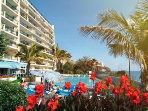 een zwembad met rode bloemen voor een hotel bij Lovely apartment with pool and sea view in Funchal