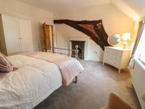 ein Schlafzimmer mit einem Bett und einem Kamin in der Unterkunft Hobson's Cottage 10 Main Street in Ilkeston