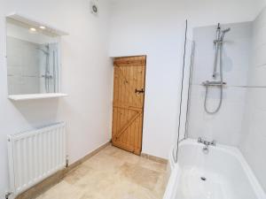 ein Bad mit einer Dusche, einem WC und einer Tür in der Unterkunft Hobson's Cottage 10 Main Street in Ilkeston + 12 Fotos