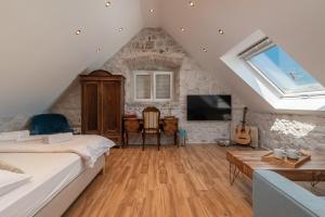 a attic bedroom with a bed and a living room at Residence Providenca in Trogir