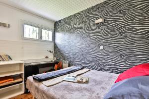 a bedroom with a patterned wall with a bed at La Presque Basque in Labenne