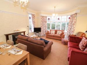 a living room with couches and a fireplace at Seawinds in Colwyn Bay