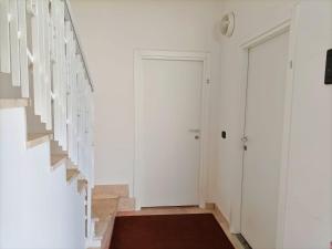 a hallway with white walls and a staircase with art on the wall at Affitta Camere Elena in Colà di Lazise