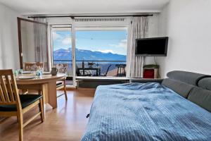 a living room with a couch and a large window at Appartement chaleureux avec une magnifique vue in Crans-Montana